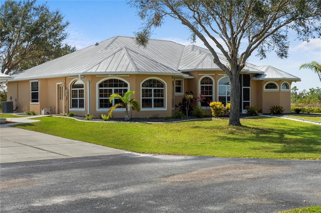 ranch-style home featuring a front yard and central AC unit