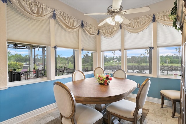 dining space featuring a water view, ceiling fan, and a healthy amount of sunlight