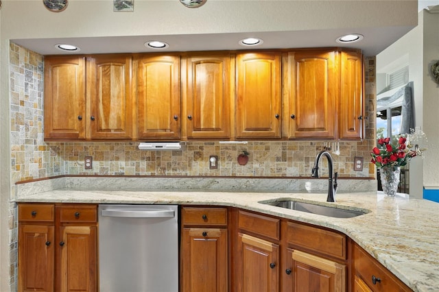 kitchen with decorative backsplash, stainless steel dishwasher, sink, and light stone counters