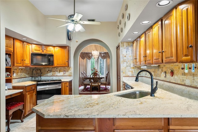 kitchen featuring sink, kitchen peninsula, stainless steel electric range oven, a high ceiling, and ceiling fan