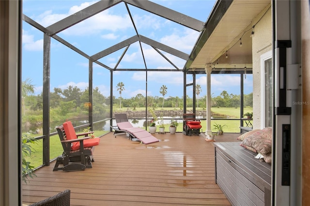 wooden terrace featuring a lanai and a water view