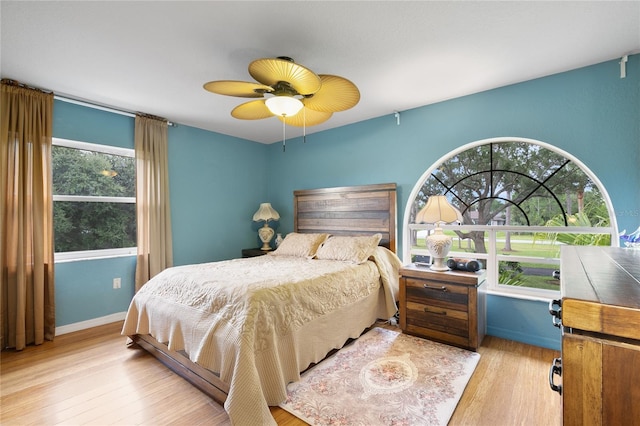 bedroom with light hardwood / wood-style floors, multiple windows, and ceiling fan