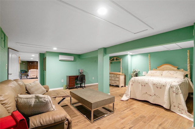 bedroom with light hardwood / wood-style flooring and a wall unit AC