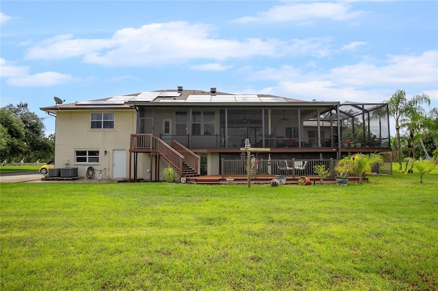 back of house featuring a deck, a yard, a sunroom, and central AC unit