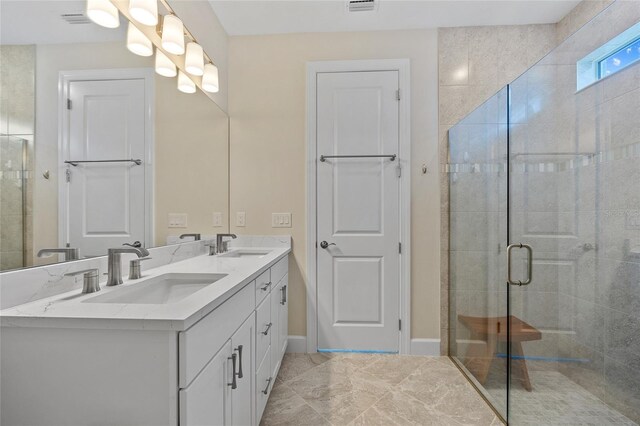 bathroom featuring a shower with shower door and vanity