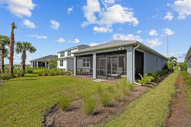 back of house featuring a sunroom and a yard