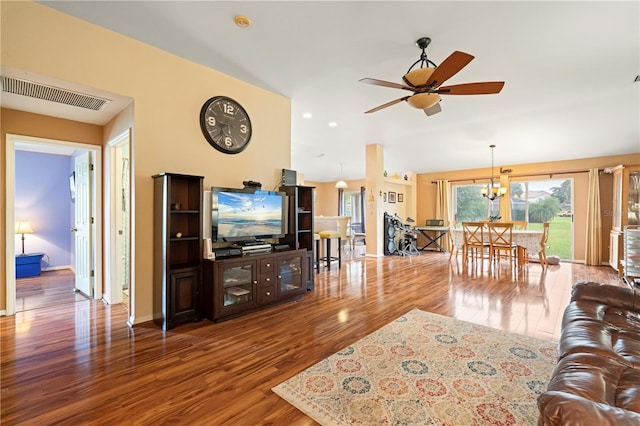 living room featuring ceiling fan with notable chandelier and wood-type flooring