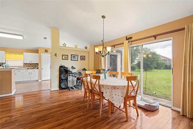 dining area featuring lofted ceiling, a healthy amount of sunlight, a notable chandelier, and light tile patterned flooring