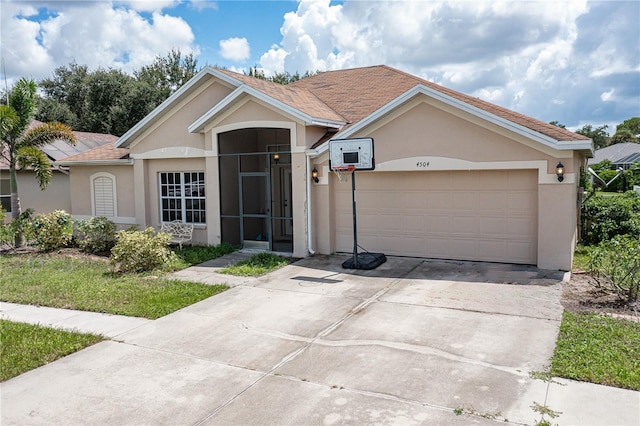 ranch-style house with a garage, concrete driveway, and stucco siding