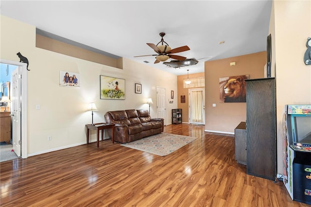 living area featuring wood finished floors, a ceiling fan, and baseboards