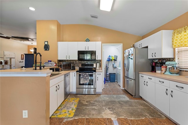 kitchen with stainless steel appliances, lofted ceiling, backsplash, and a peninsula