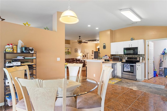 dining room featuring lofted ceiling, ceiling fan, and dark tile patterned floors