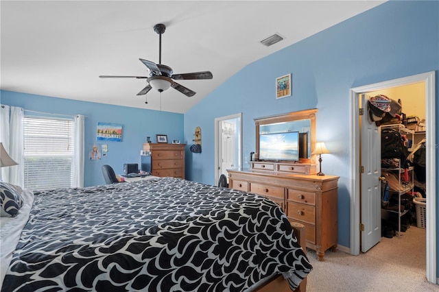 bedroom with a spacious closet, a closet, lofted ceiling, light colored carpet, and ceiling fan