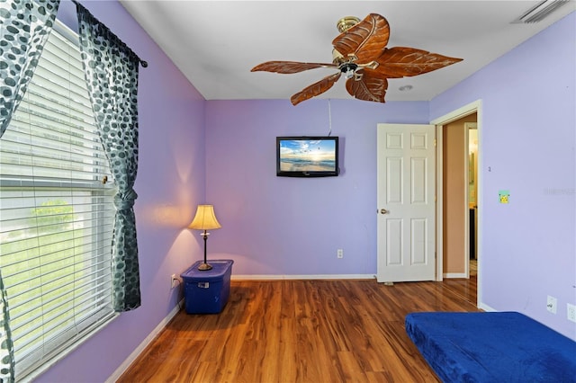 unfurnished bedroom with a ceiling fan, visible vents, baseboards, and wood finished floors