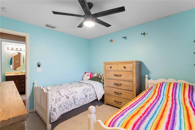 bedroom with ceiling fan, light carpet, and connected bathroom