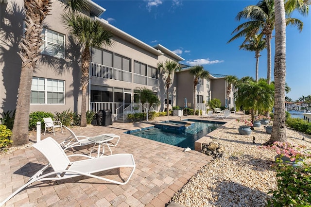 view of swimming pool featuring a patio area and an in ground hot tub