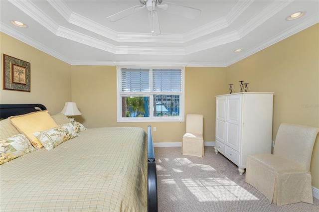 carpeted bedroom featuring a tray ceiling, ceiling fan, and crown molding