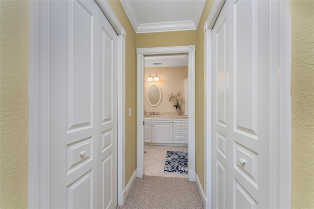 hallway with crown molding, light carpet, and sink