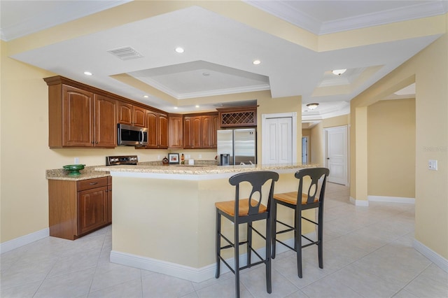 kitchen with appliances with stainless steel finishes, light stone counters, and an island with sink