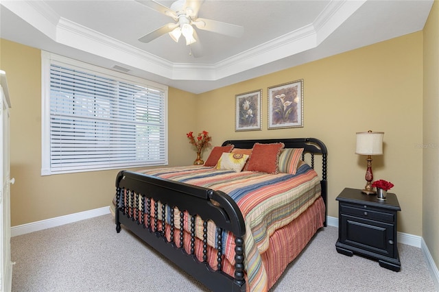 bedroom with a tray ceiling, ceiling fan, and carpet floors