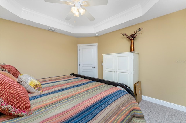 bedroom with ornamental molding, a raised ceiling, ceiling fan, and carpet