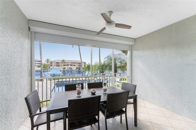 sunroom with a water view and ceiling fan