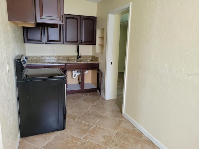 kitchen featuring black electric range, sink, dark brown cabinetry, and light tile patterned floors