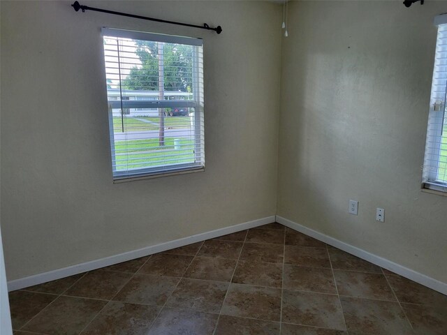 unfurnished room with dark tile patterned floors