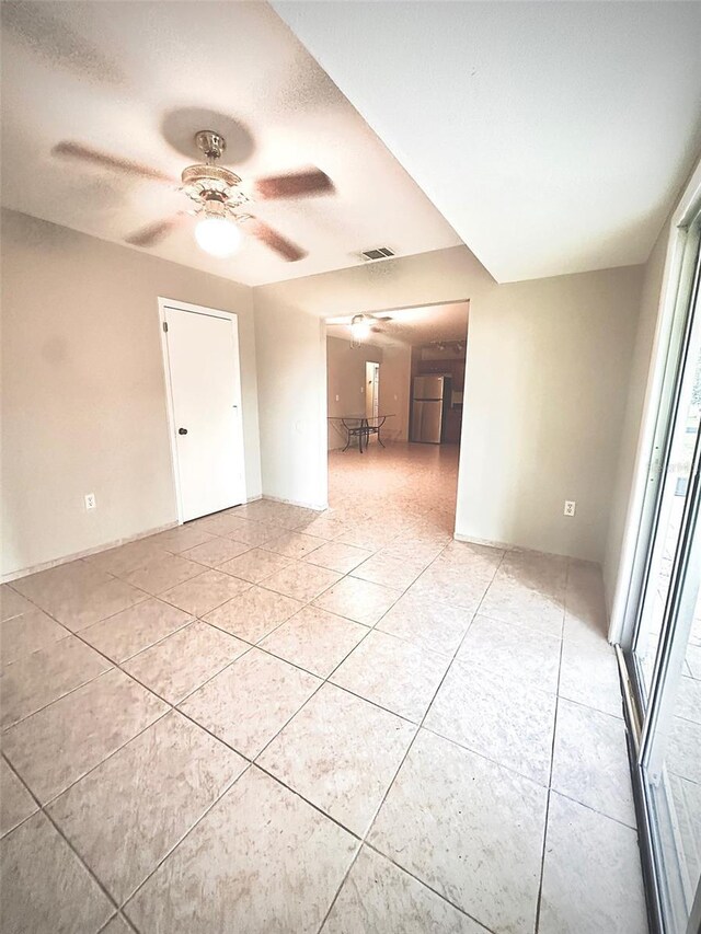 tiled empty room with a textured ceiling and ceiling fan