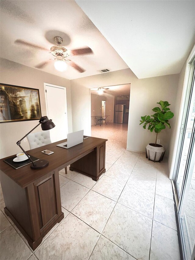 office featuring ceiling fan, light tile patterned floors, and a textured ceiling