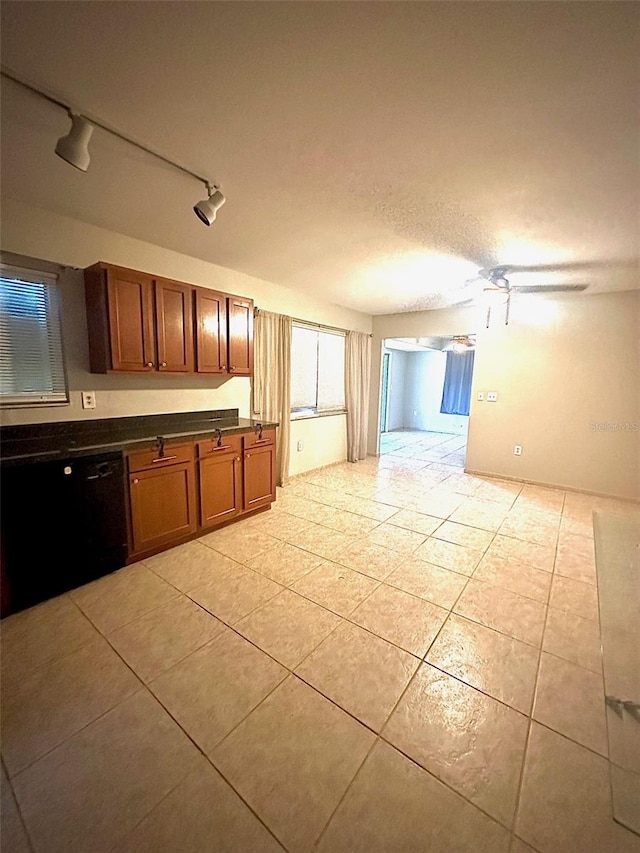 kitchen with light tile patterned floors, dishwasher, track lighting, ceiling fan, and a textured ceiling