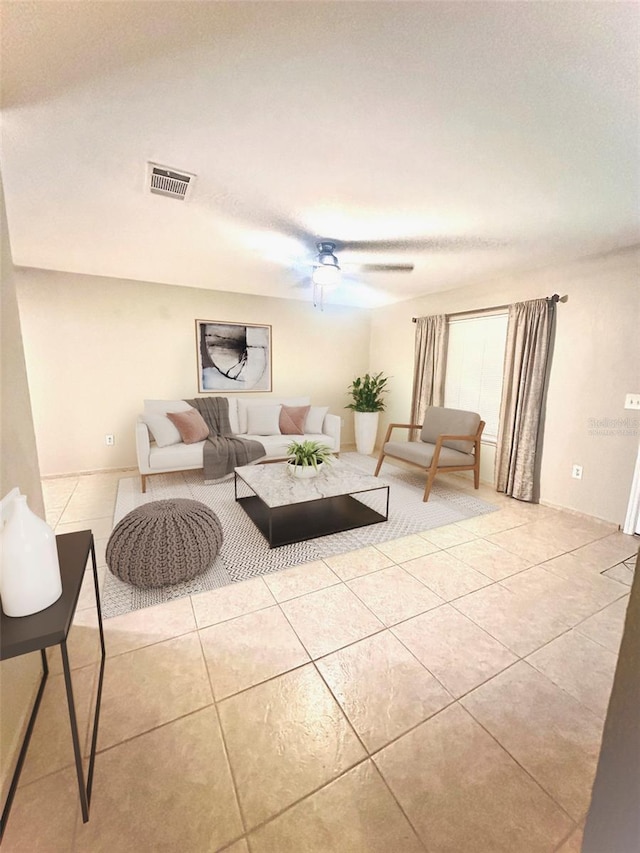 living area with tile patterned flooring, visible vents, and ceiling fan