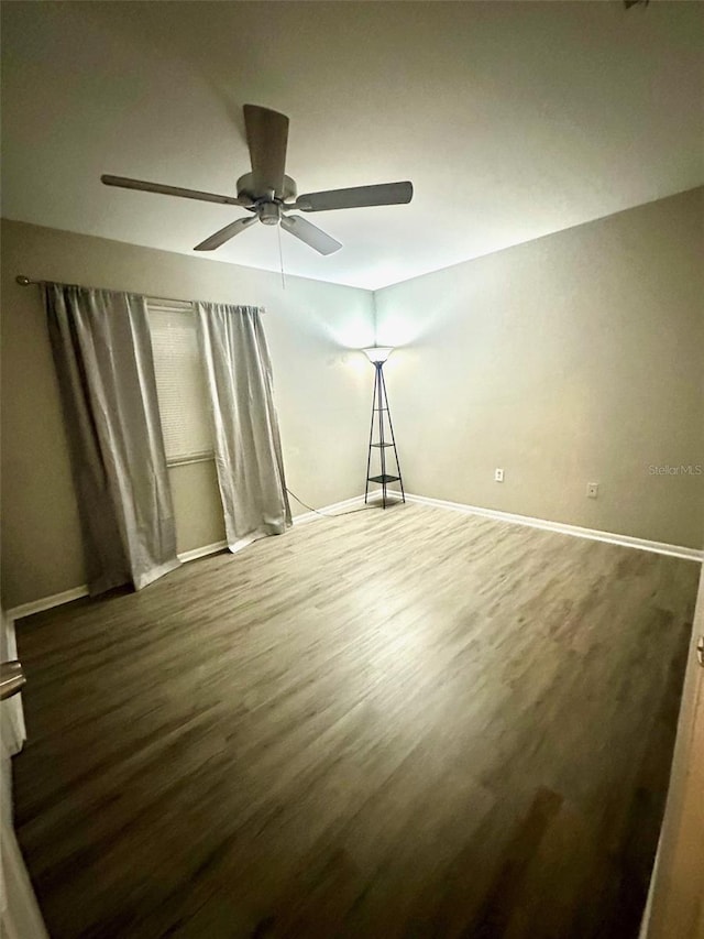 unfurnished room with ceiling fan and dark hardwood / wood-style floors