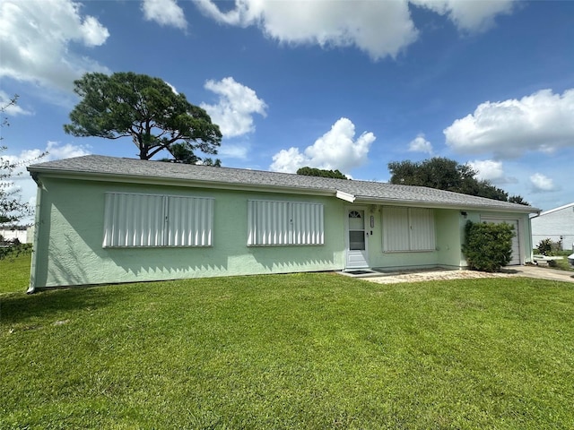 view of front of property with a garage, stucco siding, and a front lawn