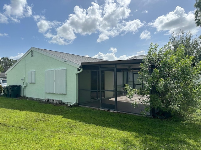 rear view of property with a patio area, stucco siding, and a yard