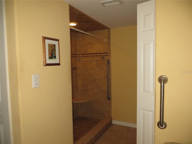 bathroom with tiled shower and tile patterned floors