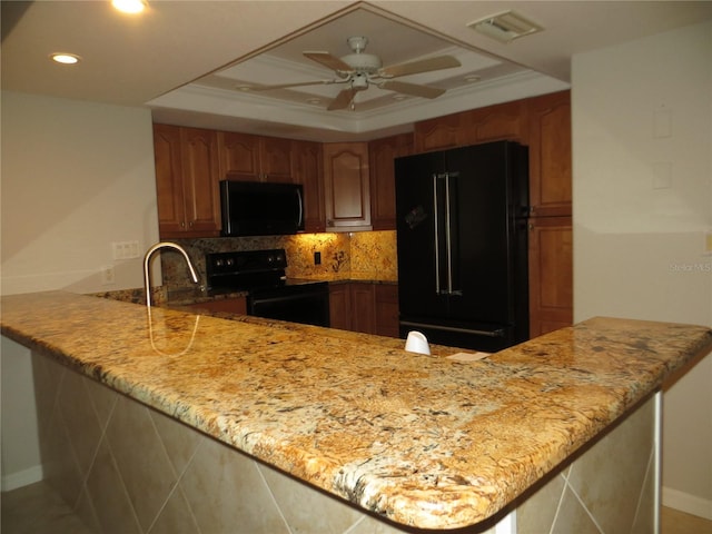 601 Shreve St Unit 12B, Punta Gorda, FL 33950 - kitchen with black appliances, a peninsula, backsplash, light stone counters, and recessed lighting