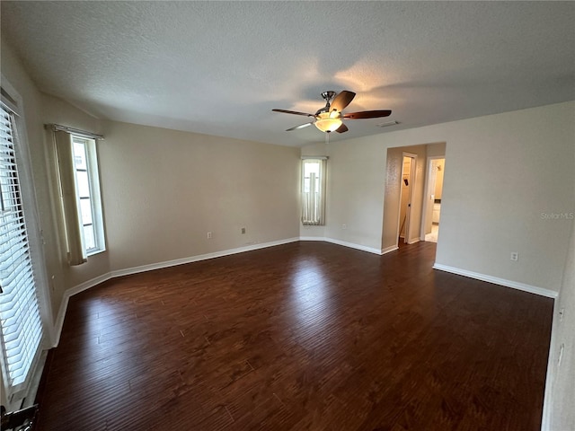 empty room with a textured ceiling, ceiling fan, and dark hardwood / wood-style floors