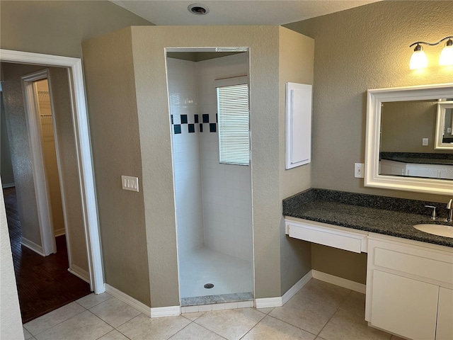 bathroom featuring vanity, hardwood / wood-style flooring, and a tile shower