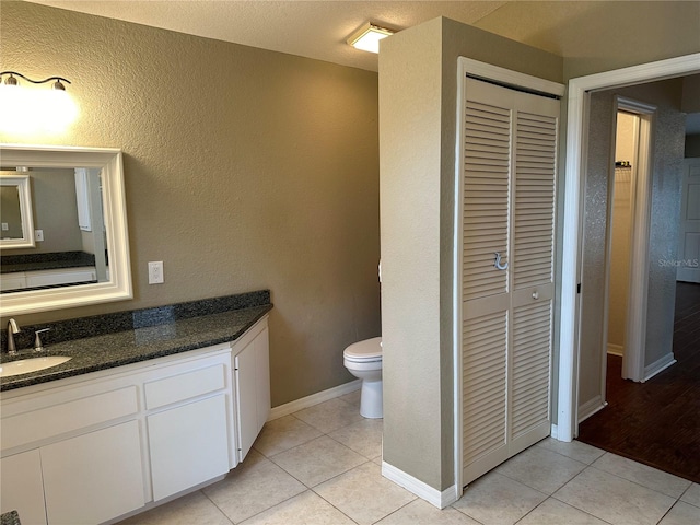 bathroom featuring vanity, toilet, and tile patterned flooring