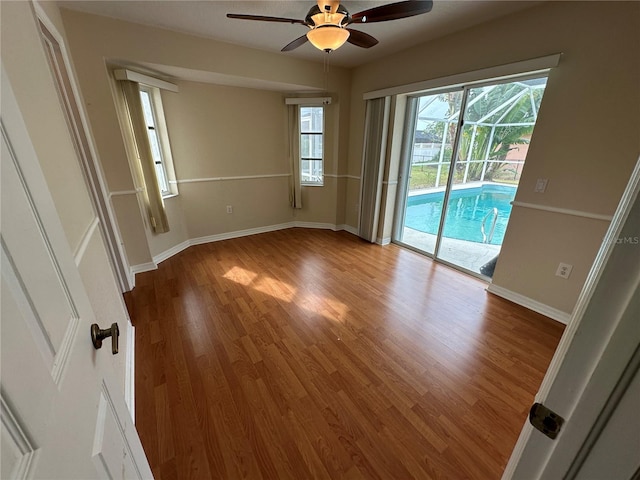 empty room with hardwood / wood-style floors and ceiling fan