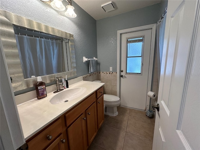 bathroom featuring curtained shower, tile patterned flooring, toilet, and vanity