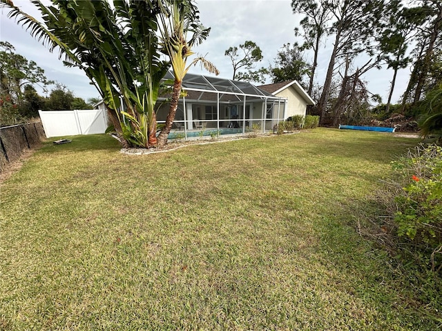 view of yard with glass enclosure and a swimming pool