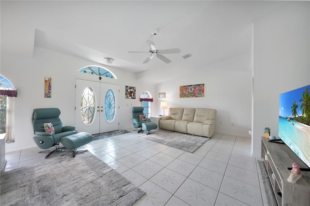 living room with lofted ceiling, ceiling fan, light tile patterned floors, and plenty of natural light