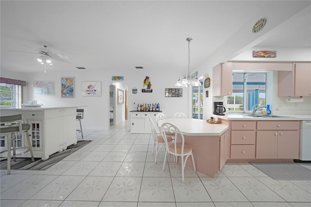 kitchen with dishwasher, light brown cabinetry, sink, and ceiling fan with notable chandelier