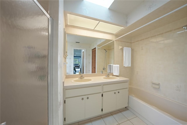 bathroom featuring tile patterned flooring, tiled shower / bath combo, and vanity