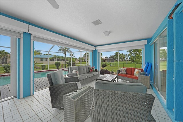 sunroom / solarium featuring a ceiling fan