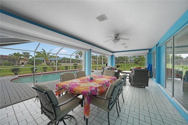 sunroom with a swimming pool and ceiling fan