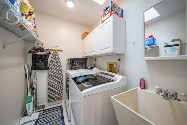 laundry room with cabinets, washing machine and clothes dryer, and sink