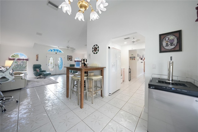 kitchen with arched walkways, ceiling fan with notable chandelier, visible vents, french doors, and white fridge with ice dispenser